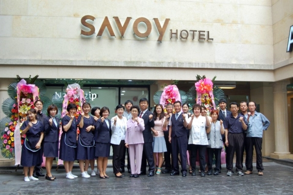 분홍색 옷을 입은 신현숙 회장(가운데)이 사보이호텔 직원들과 사진을 찍고 있다. ⓒ사보이호텔