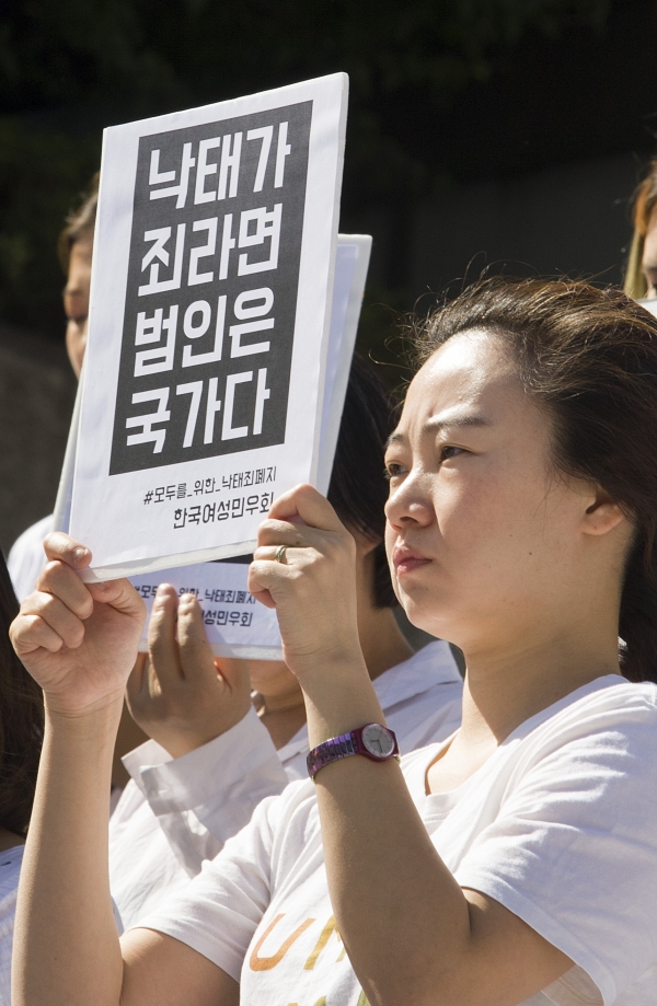 28일 오전 11시 반 서울 광화문 세종문화회관 계단 앞에서 열린 ‘모두를 위한 낙태죄 폐지 공동행동’ 발족 퍼포먼스 행사에 참석한 여성이 피켓을 들고 있다. ⓒ이정실 여성신문 사진기자