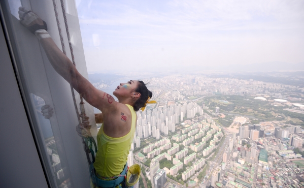 클라이밍 여제 김자인이 20일 국내 최고층 건물(555m)인 서울 송파구 롯데월드타워를 맨손으로 오르고 있다. ⓒ뉴시스·여성신문