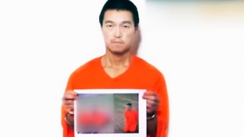 25일(현지시각) IS가 일본인 인질 한 명을 참수했다고 자체 방송했다. 인질 중 한 명인 고토 겐지가 참수된 유카와 하루나의 시신이 찍힌 사진을 들고 있다. ⓒ유튜브 영상 캡쳐