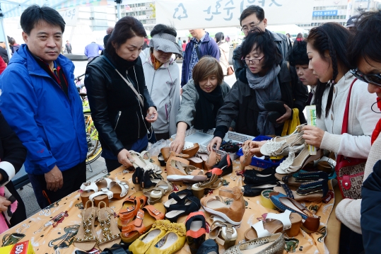 나눔 장터에선 자원 순환의 의미를 배울 수 있다. 지난해 11월 서울 종로구 광화문 광장에서 열린 광화문 희망나눔 장터에서 시민들이 신발을 고르고 있다. ⓒ뉴시스‧여성신문