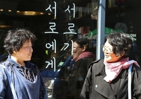 나낮잠(왼쪽) 출판사 ‘움직씨’ 대표와 노유다 대표가 서울 연남동 ‘책방서로’ 앞에서 서로를 바라보며 웃고 있다. ⓒ이정실 여성신문 사진기자