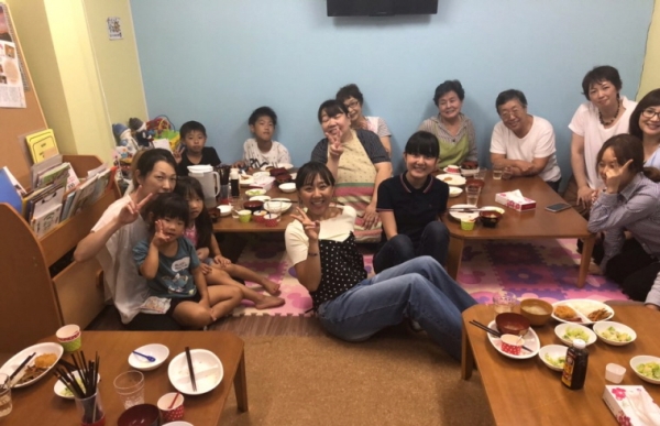 일본 카스카베시에 위치한 어린이식당 히나타에서 저녁밥을 먹은 아이들과 식당 자원봉사자들이 함께 기념촬영을 했다. 식당에는 식사하는 70대 어르신도 있었다.