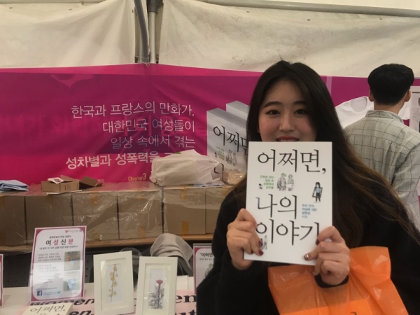 서울와우북페스티벌 여성신문 부스에서 만난 정다예(23)씨가 『어쩌면 나의 이야기』를 구매한 뒤 기념사진을 찍고 있다. ⓒ이유진 기자
