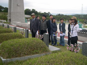 Women visitors are listening to a woman activist who explains the meaning of Gwangju womens activities during the democratic uprising in 1980 at the May 18 Democratic Cemetery in Mangwoldong.