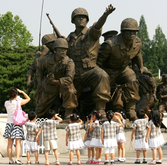 Children looking at statues of soldiers at the War Memorial of Korea in Yongsan.   ⓒ Women News DB