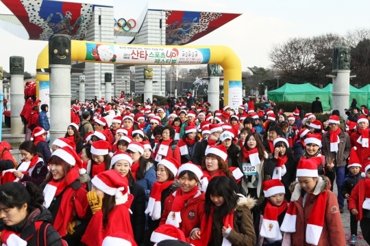 The 2013 Santa Sports Up Festival was held on the 7th at Peace Plaza in Olympic Park, Songpa-Gu, Seoul. Participants of 5km marathon in Santa outfits are passing the starting line. ⓒ Lee Jeong-sil Women’s News Photographer