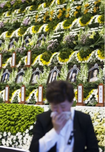 A mourner crying at the Ansan Olympic Hall, a makeshift mass memorial altar for Danwon High School students and teachers who were killed due to the sinking of the ferry Sewol.